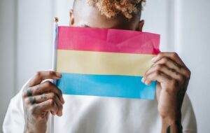 Person holding up pansexual pride flag