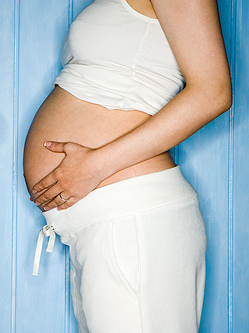 Pregnant person holding their belly.