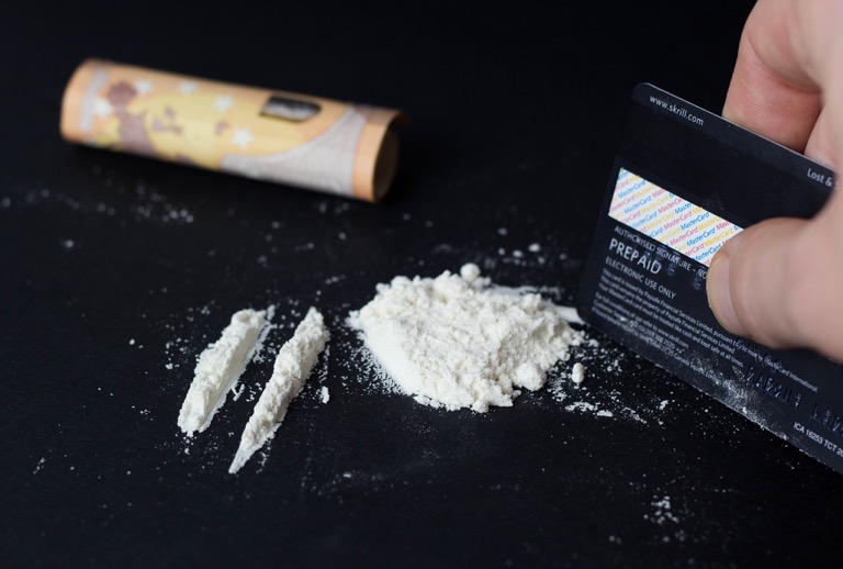 Two lines of a white powder substance. There is also a pile of the white powder substance and a credit card next to it.