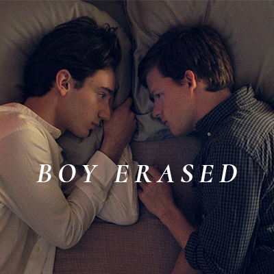 Two men laying on a bed, facing each other. The words "BOY ERASED" are overlaid.