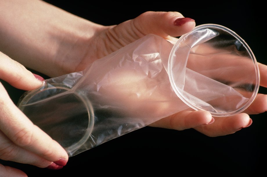 Hands holding a female condom.