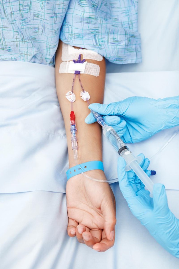 Hospital patient's arm getting needles inserted into it