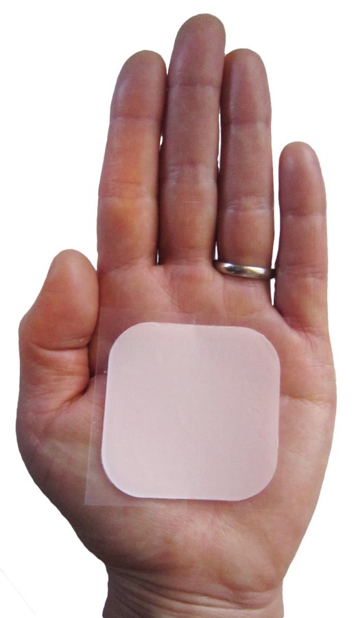A contraceptive patch on a hand.