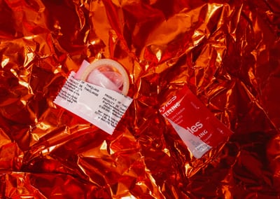 A condom on a red background.