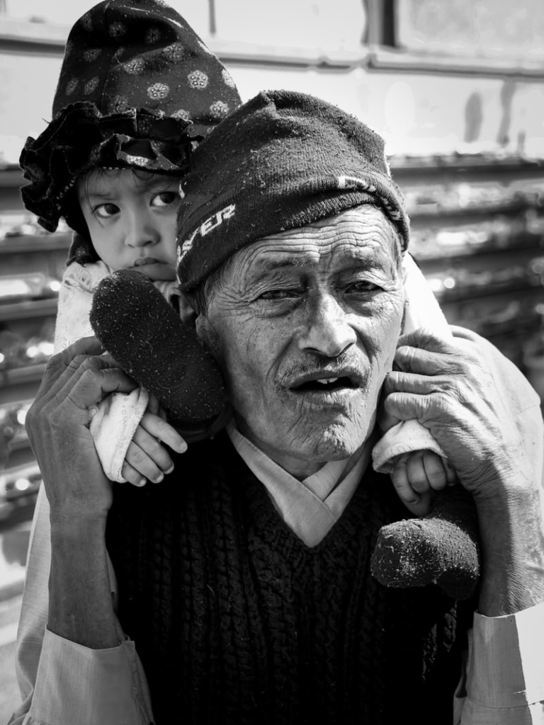 A toddler on the shoulders of an elderly man