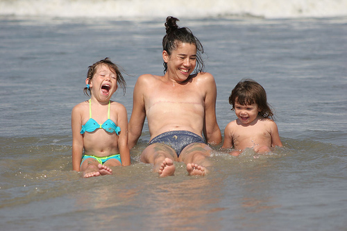 A topless person after breast removal, next to two kids.