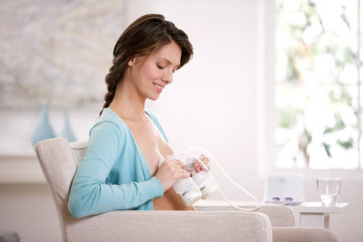 A person pumping milk from their breasts.