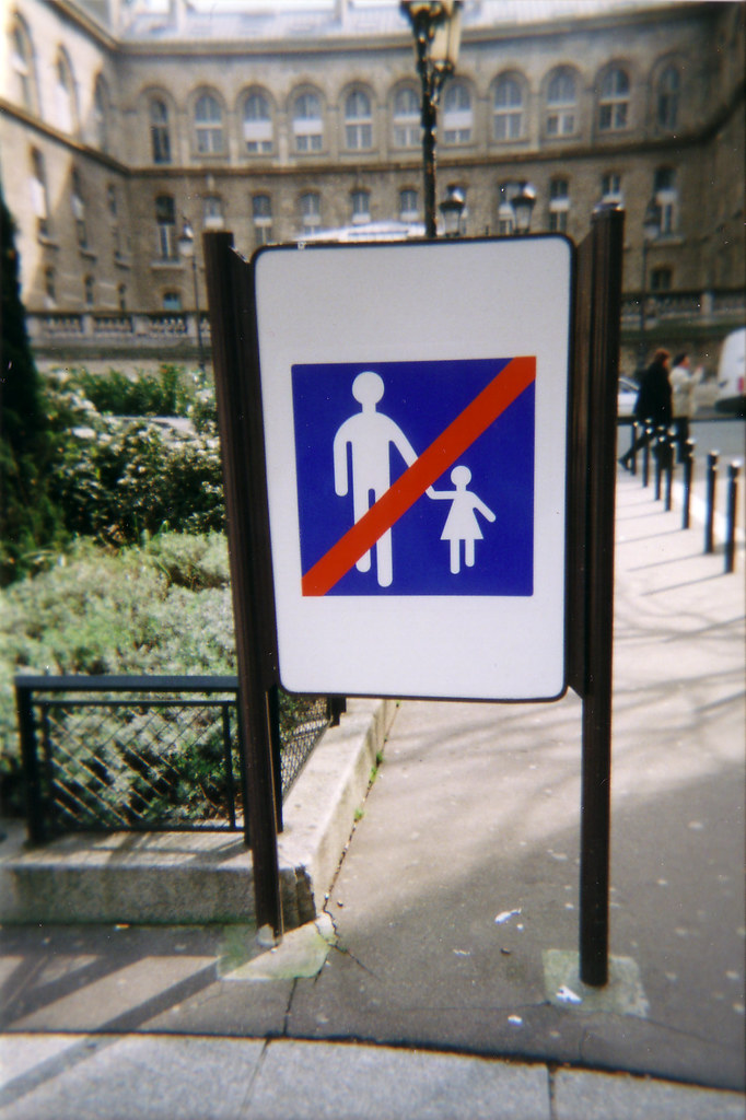 A sign of a person and a child. There is a red line across the sign.