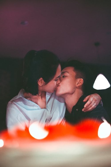 Two persons kissing on the mouth.