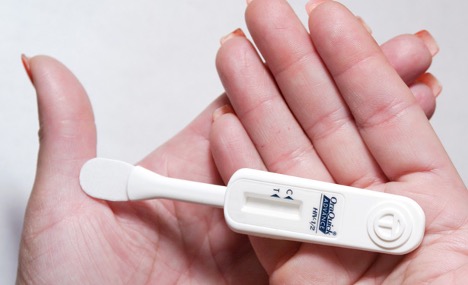 A person holding an at-home HIV test. 