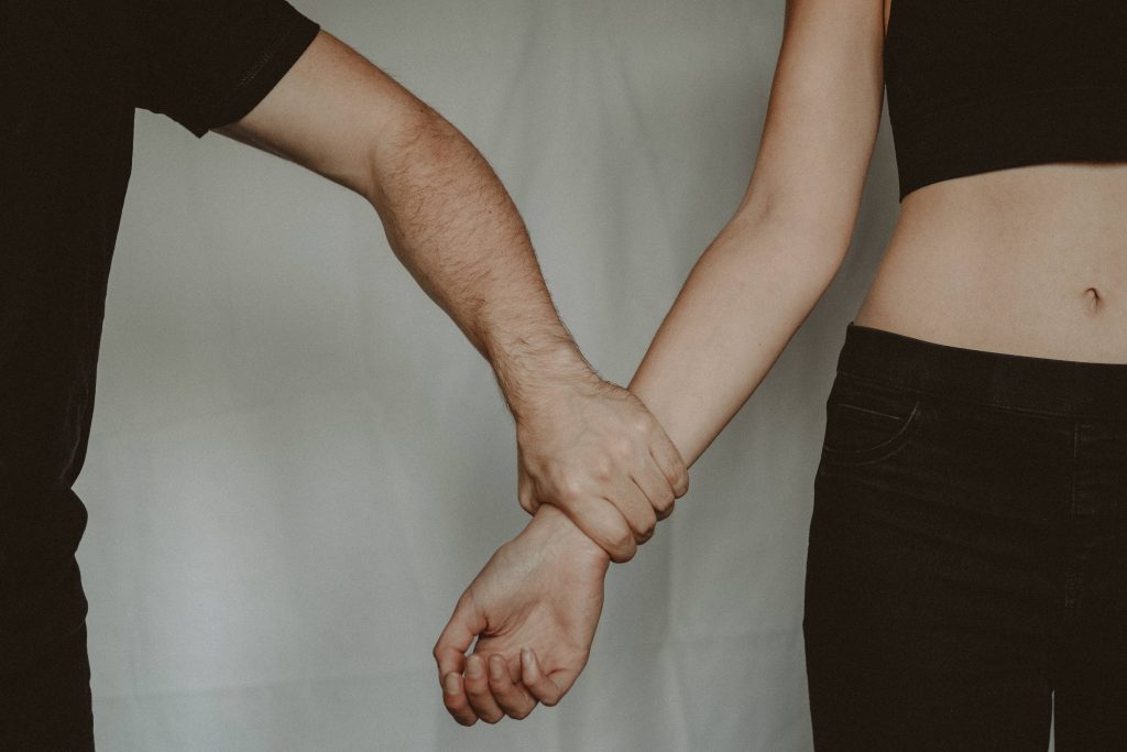 A person holding tightly to another person's wrist.