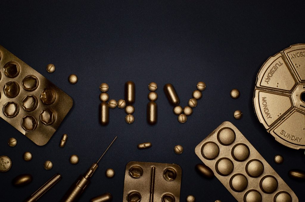 "HIV" spelled out with pills covered in gold.