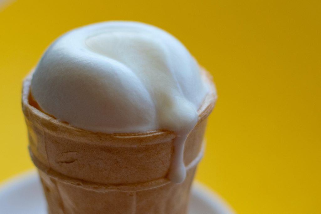 An ice cream cone with melted ice cream dripping.