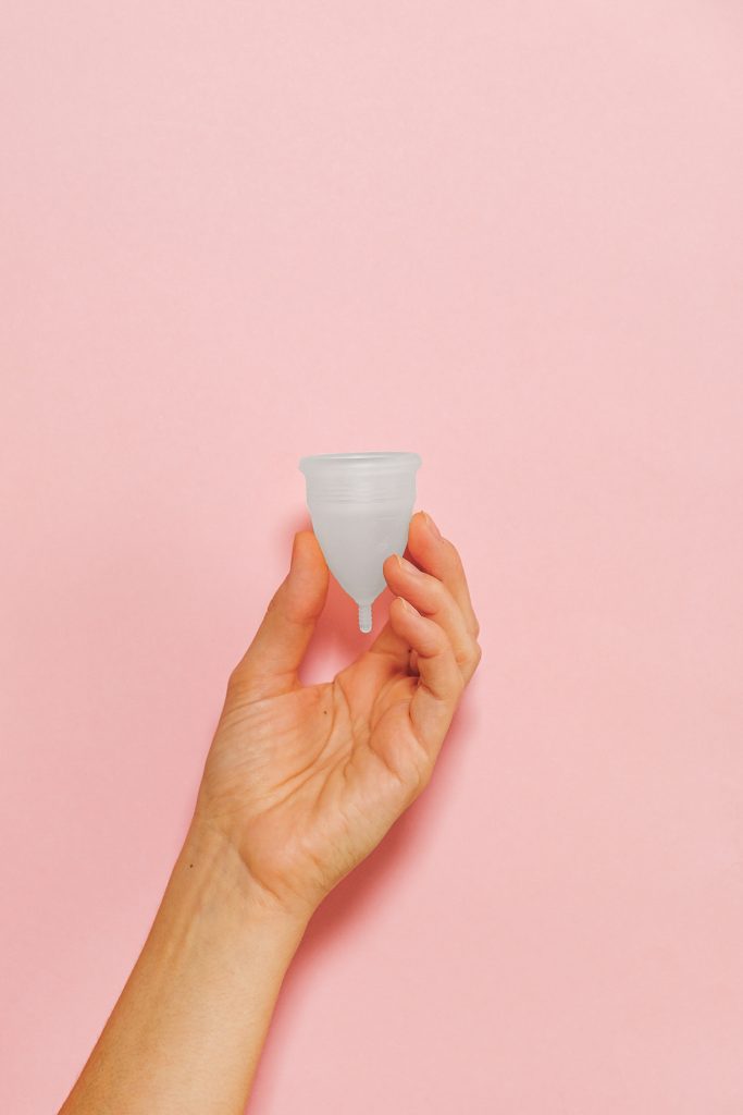 A hand holding a menstrual cup.