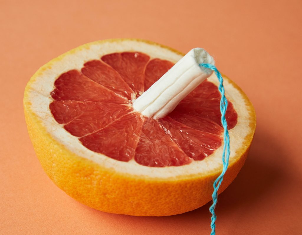 A tampon inside of a half-sliced orange.