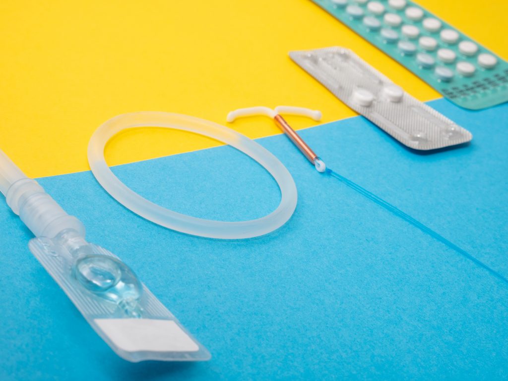 A variety of birth control methods: birth control pills, intrauterine device, and vaginal ring.