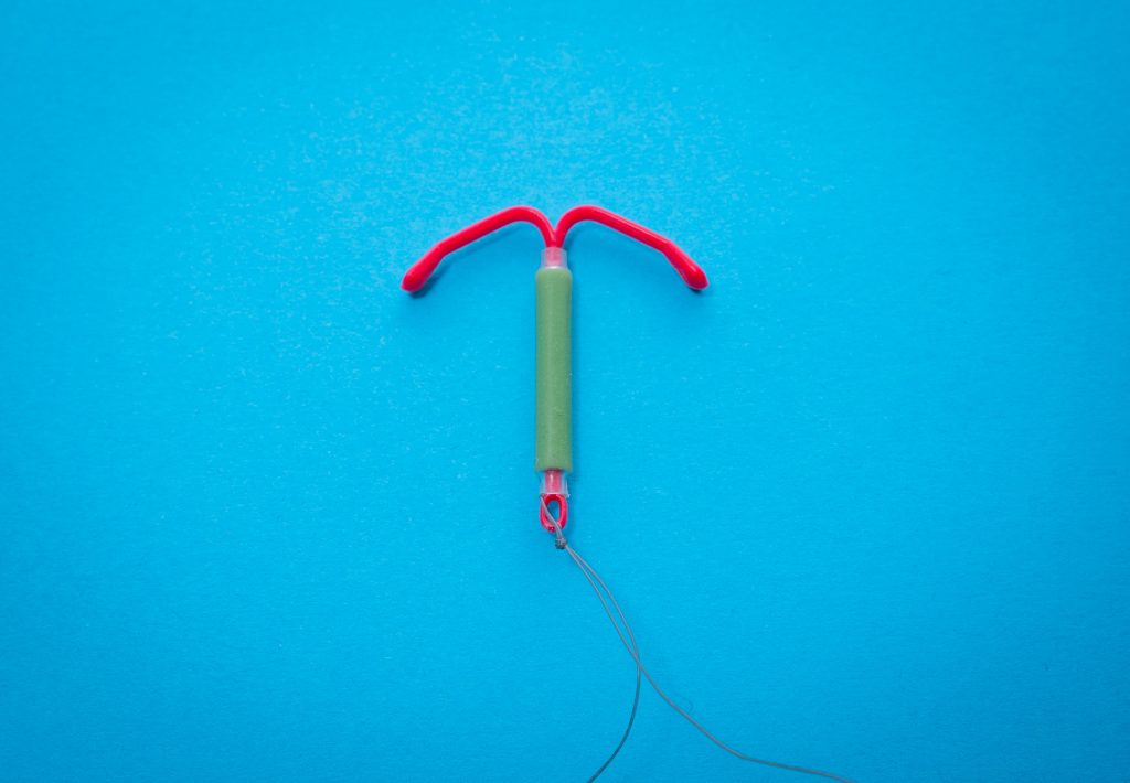 A pink and green intrauterine device.