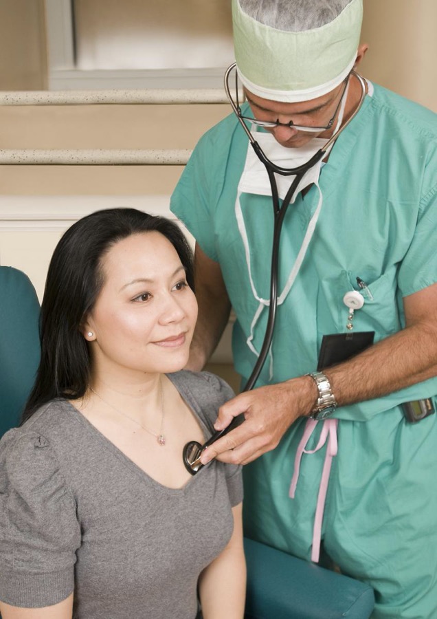 A doctor using a stethoscope on another person.