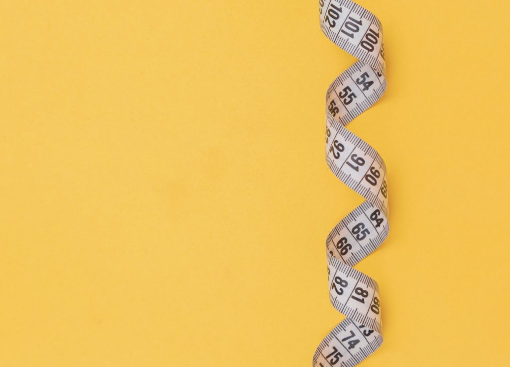 white measuring tape on yellow background