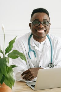 Black man wearing a white coat and stethoscope
