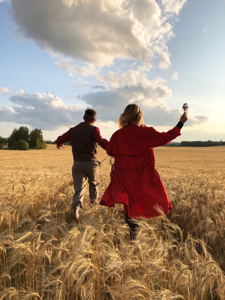 couple running through a field together