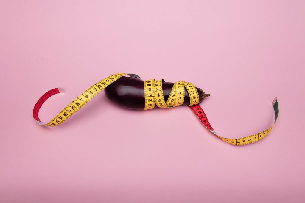 An eggplant wrapped in measuring tape.