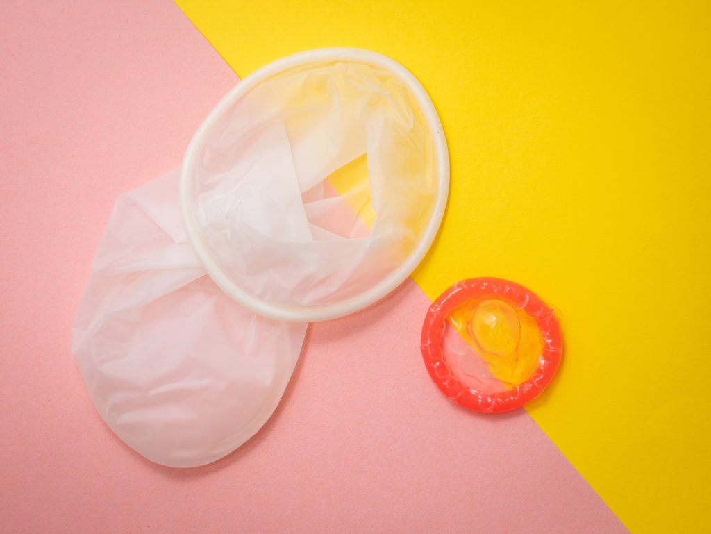 A female condom next to a male condom.
