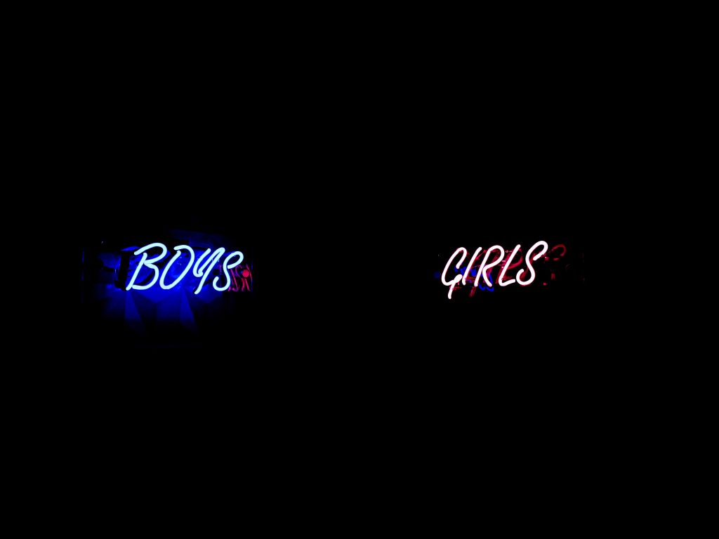 Neon blue sign that spells "boys" and neon pink sign that spells "girls."
