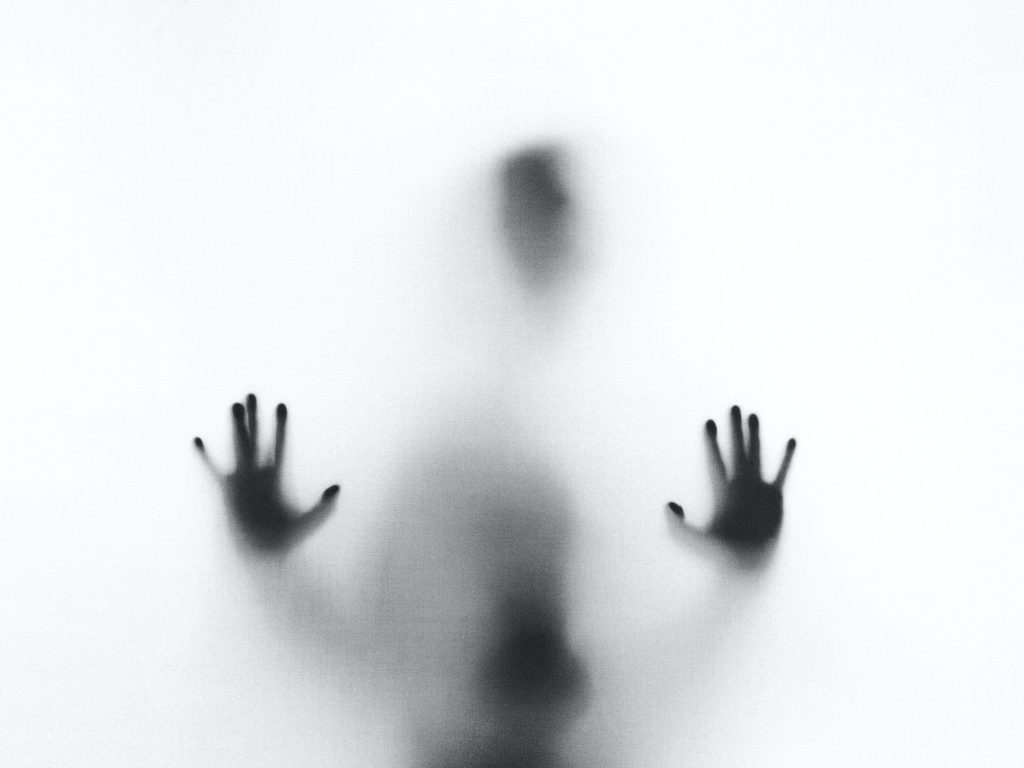 The shadow of a person with their hands raised.