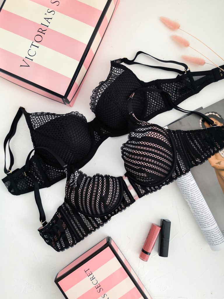 Two black bras in between two Victoria's Secret boxes.