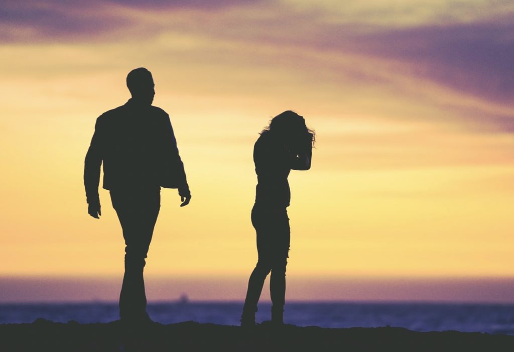 silhouettes of two people in front of sunset