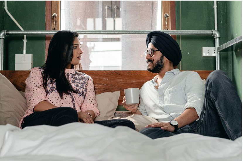 Couple sitting on bed having a calm discussion 