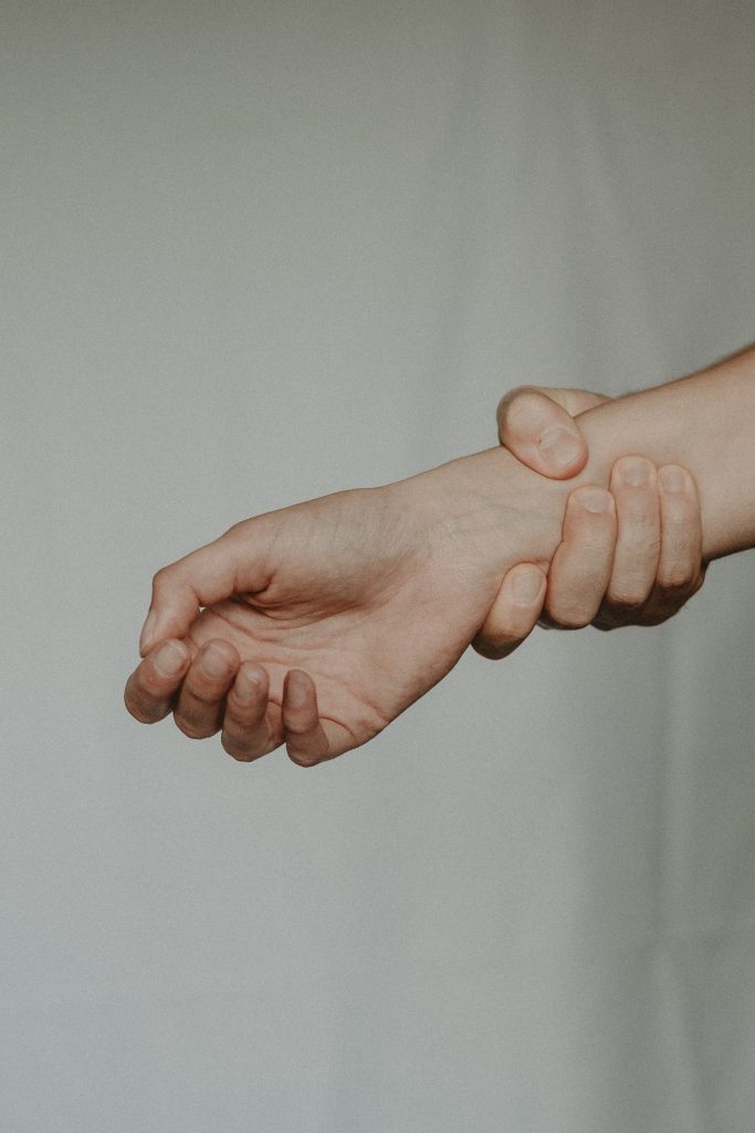 A person's hand wrapped around another person's wrist.