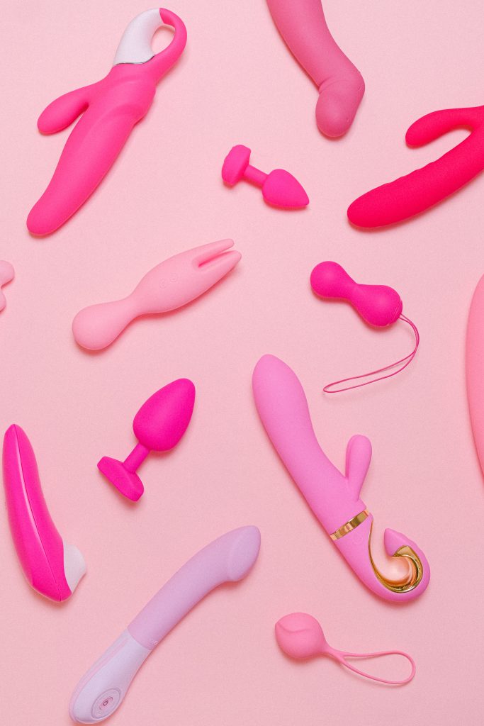 A variety of pink sex toys, including: vibrators, anal plugs, and dildos.