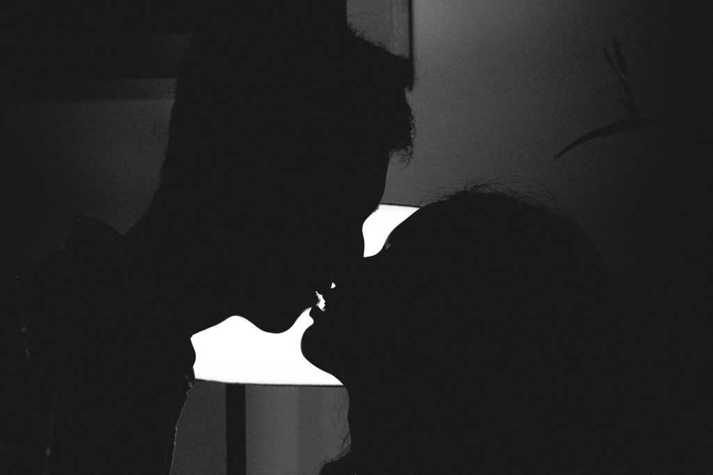 The silhouette of a couple kissing.