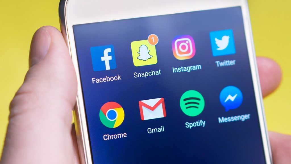 A phone screen with apps including: Facebook, Snapchat, Instagram, Twitter, Google, Gmail, Spotify, and Messenger.