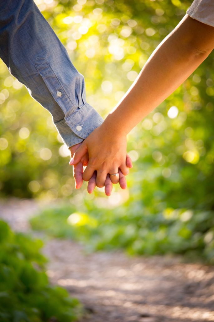 A close-up of a couple holding hands.