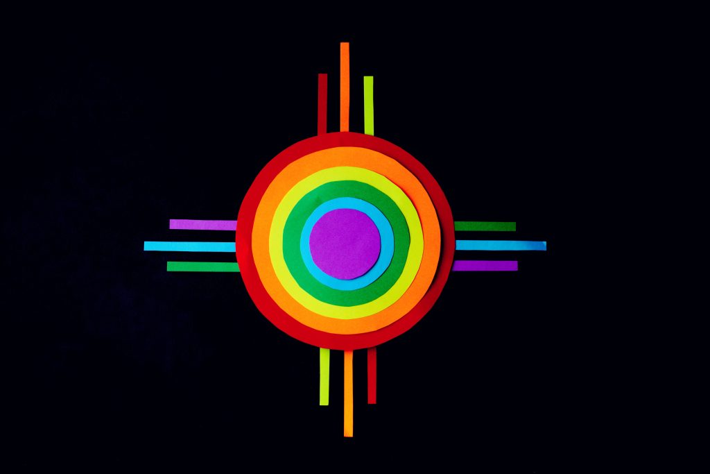 Rainbow-colored Native Sun Symbol on a black background