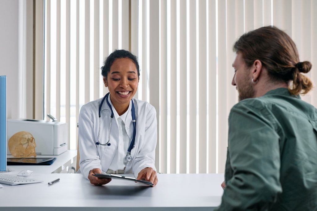 a doctor speaking with a patient over a desk