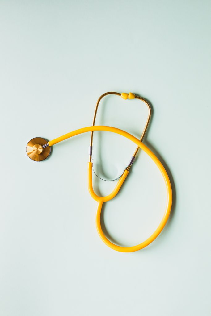 a yellow stethoscope in front of a light blue background