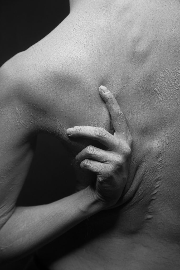Close-up of person scratching their flaky back