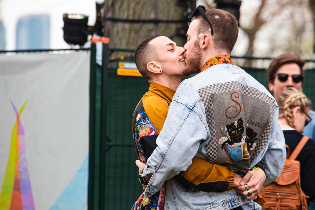 Two men kissing on the lips.
