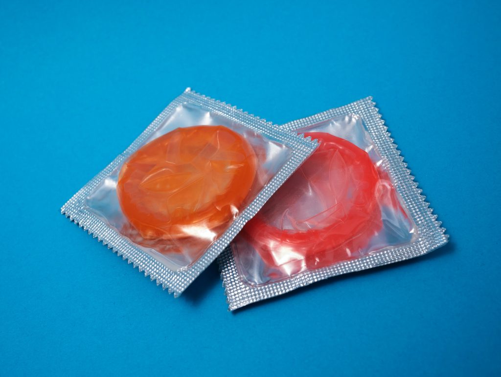 Two brightly colored condoms still in their packaging