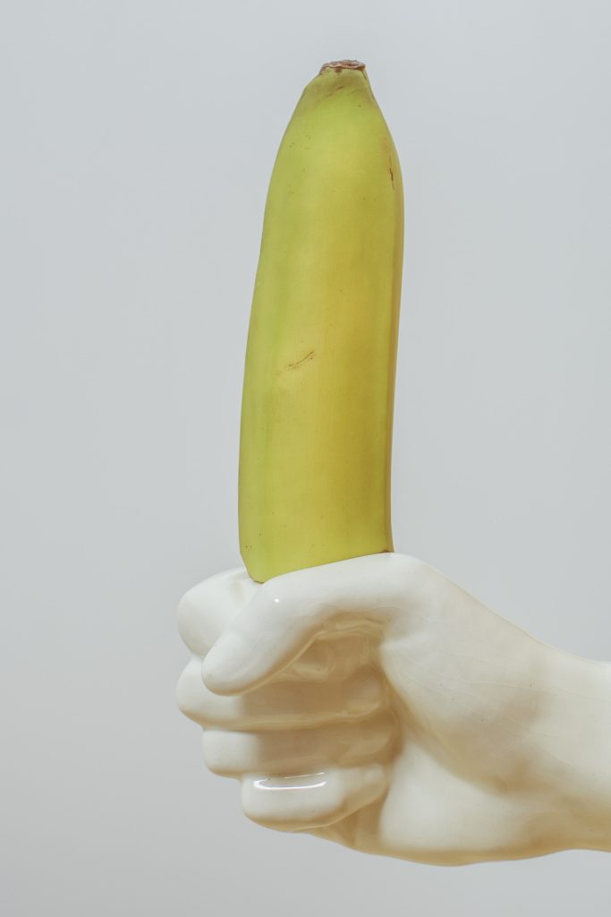A hand grasping a banana. 